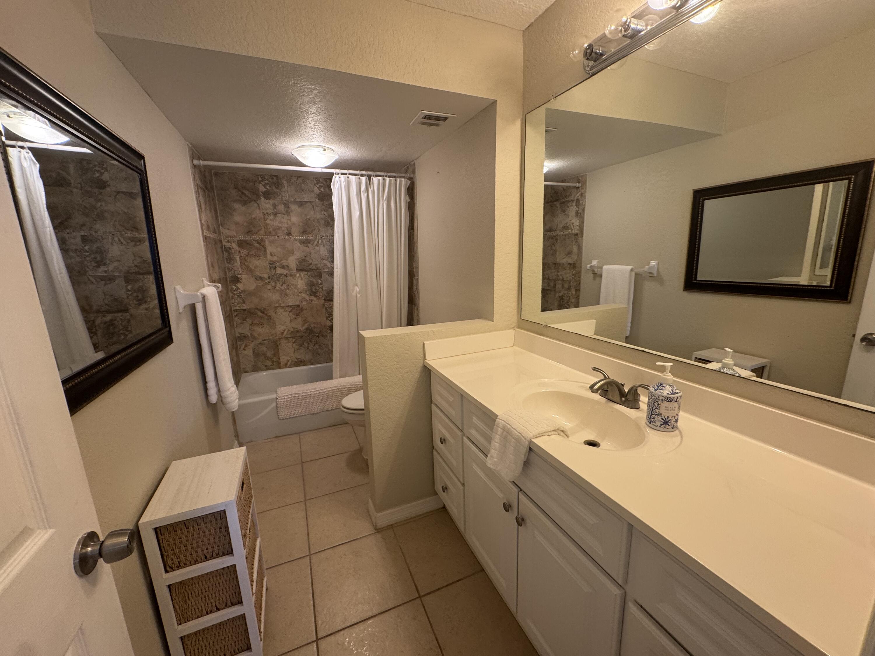 3200 North Hwy A1A, Unit 307 Hutchinson Island, FL 34949 - Photo 35 of 47 a spacious bathroom with a double vanity sink a mirror and a shower