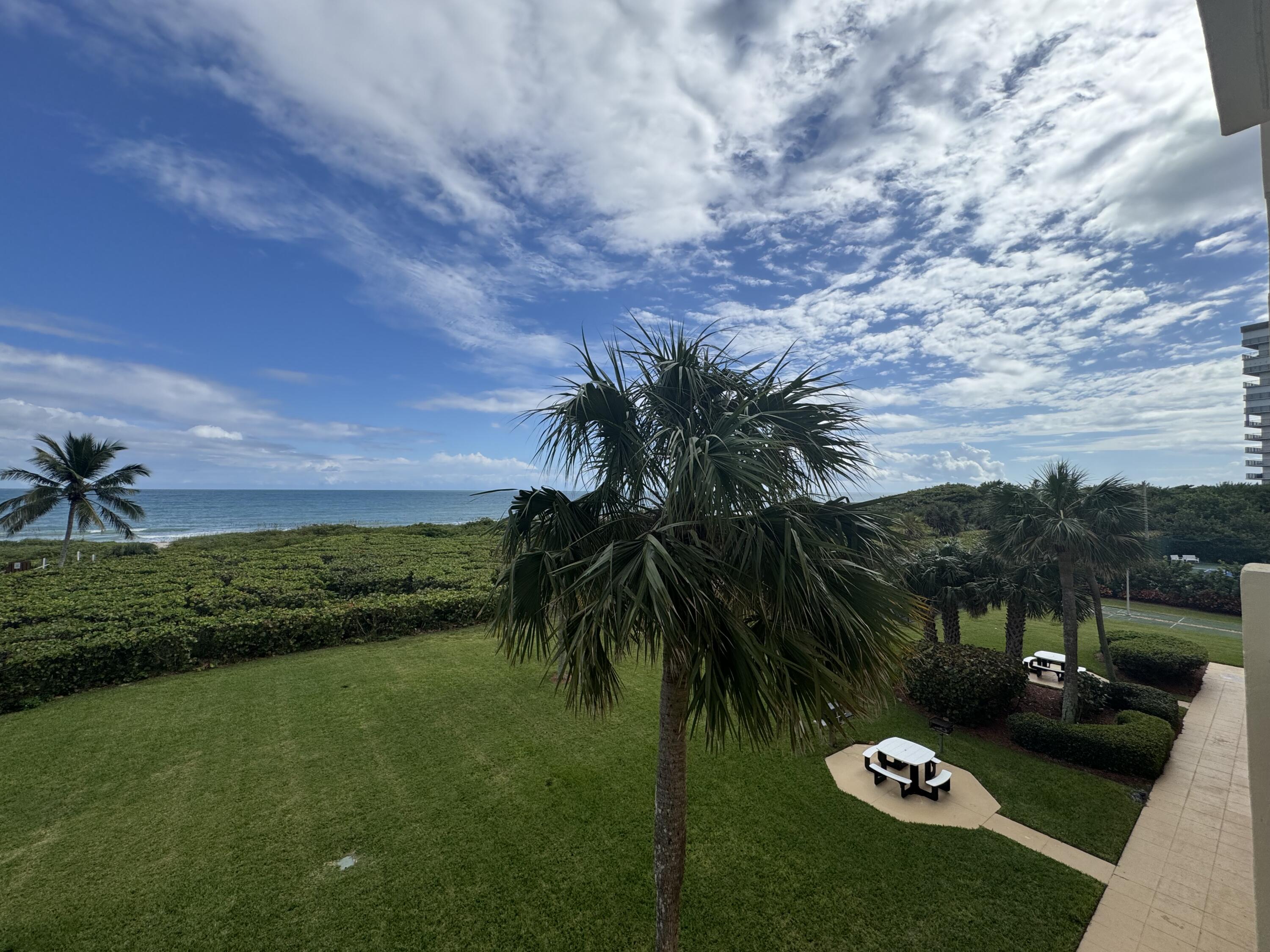 3200 North Hwy A1A, Unit 307 Hutchinson Island, FL 34949 - Photo 41 of 47 a view of a backyard with couches under an umbrella
