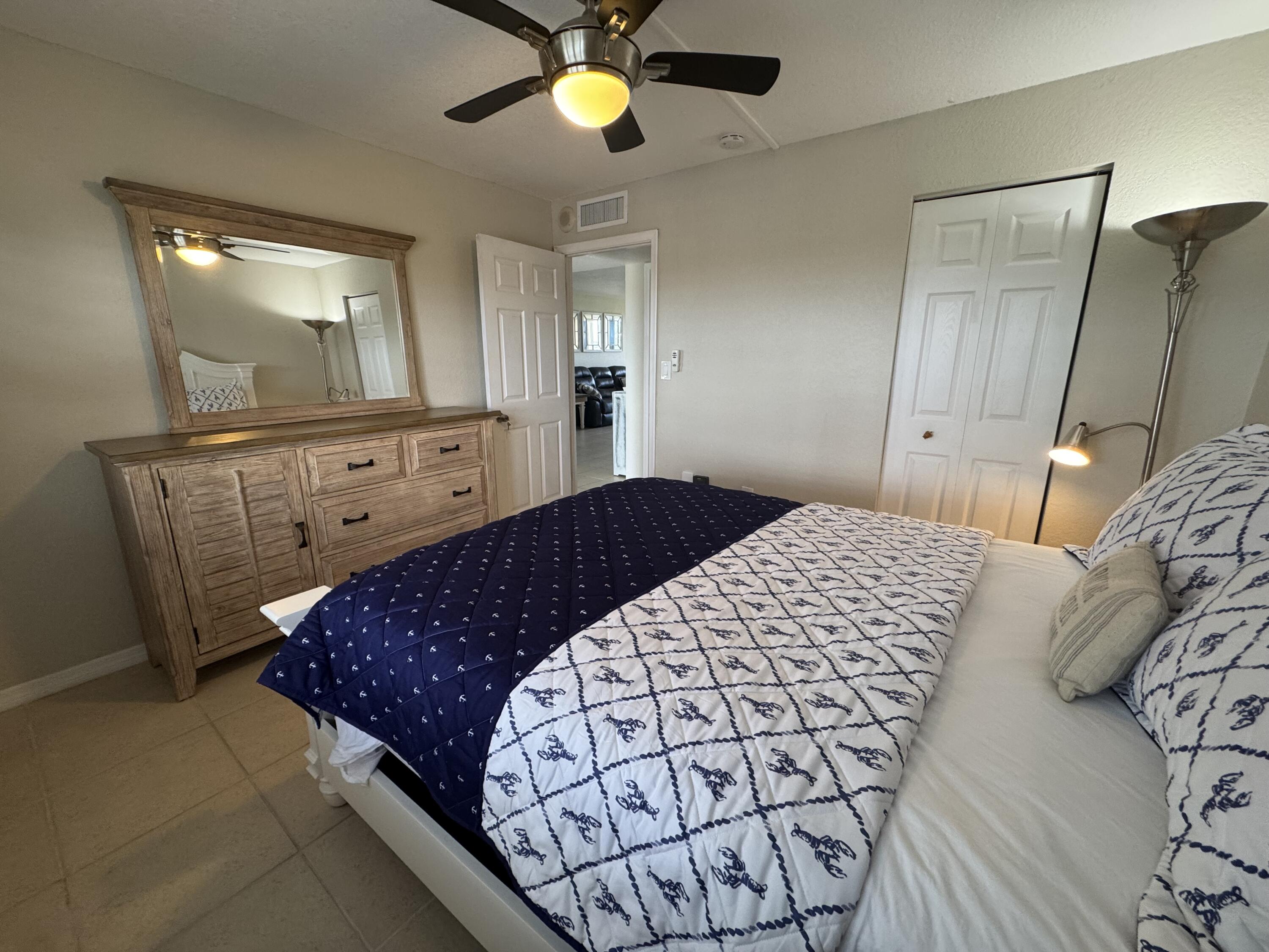 3200 North Hwy A1A, Unit 307 Hutchinson Island, FL 34949 - Photo 46 of 47 a bedroom with a bed and a mirror