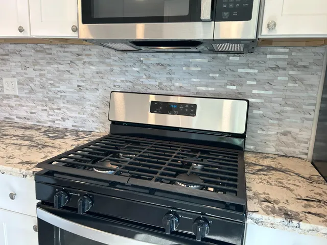 a stove top oven sitting inside of a kitchen