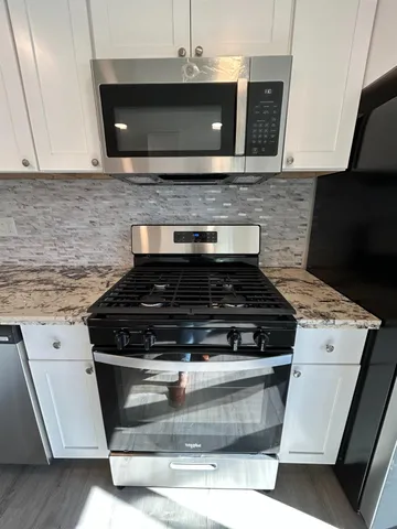 a stove top oven sitting inside of a kitchen