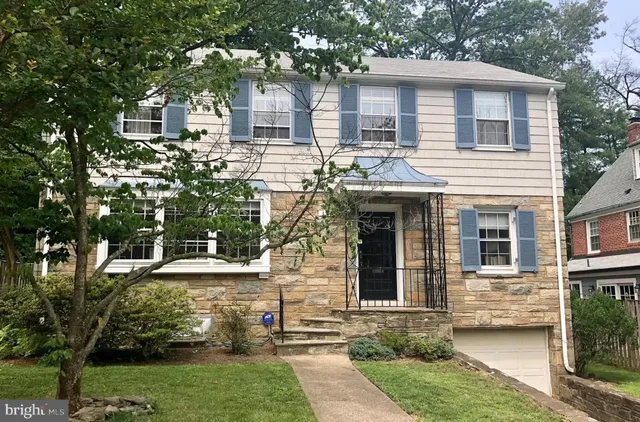 a view of a white house with a large windows and a yard