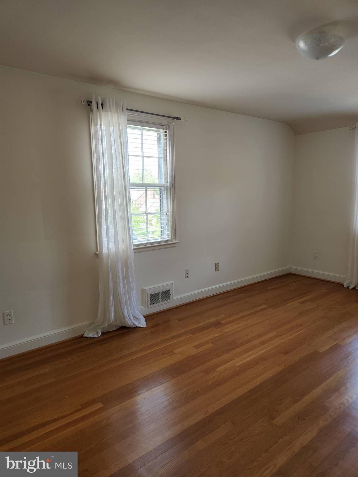 3916 48th Street Northwest Washington, DC 20016 - Photo 21 of 29 an empty room with wooden floor and windows