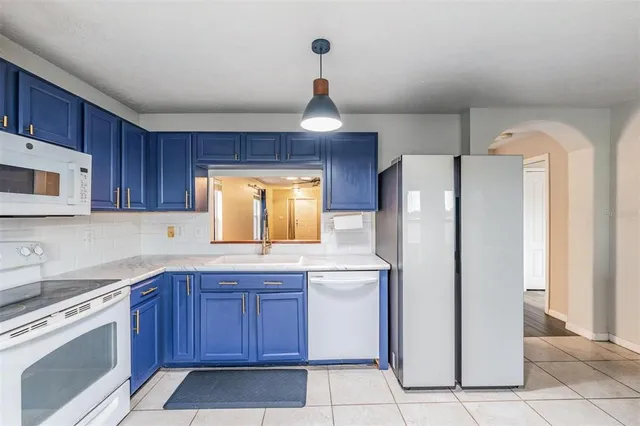 a kitchen with a refrigerator sink and cabinets