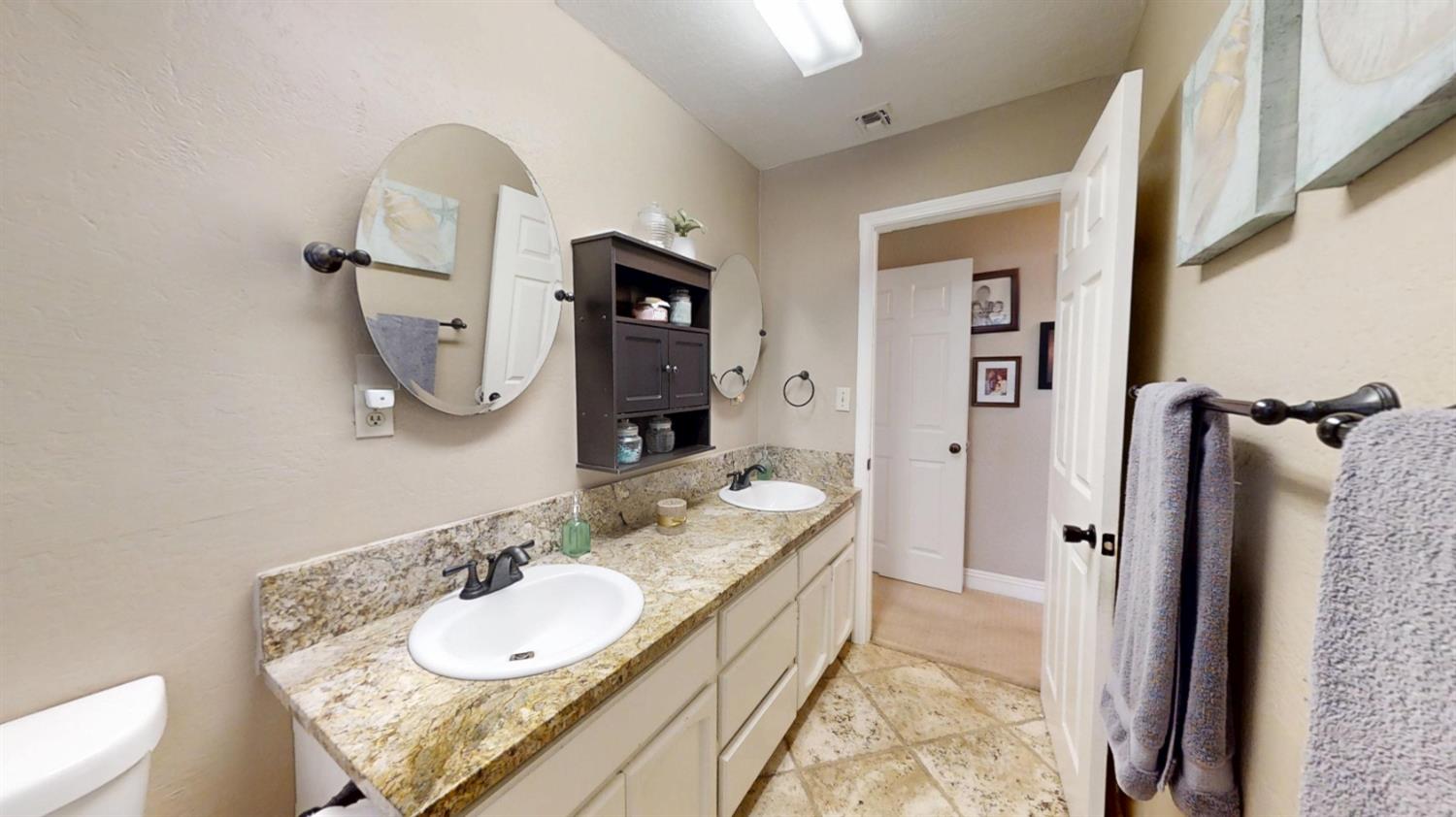 2956 Treen Court Rancho Cordova, CA 95670 - Photo 28 of 67 a bathroom with a granite countertop sink and a mirror