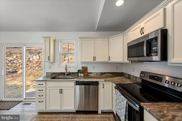 a kitchen with a refrigerator a sink and wooden floor