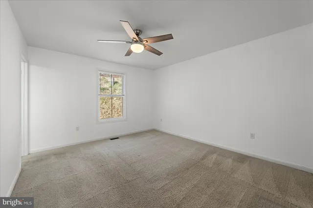 an empty room with a fan and a fan