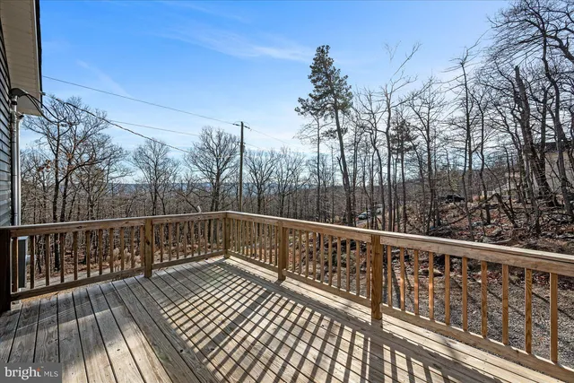 a view of a balcony with wooden floor and fence