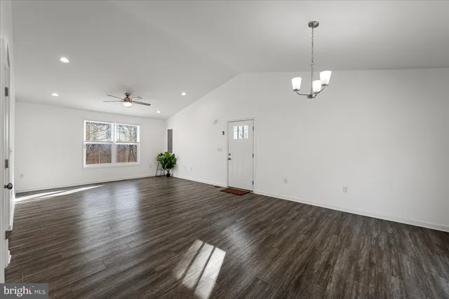 a view of empty room with wooden floor and ceiling fan