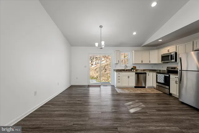 a view of empty room with wooden floor and window