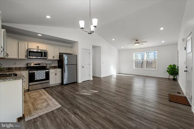 a view of kitchen with granite countertop cabinets and refrigerator