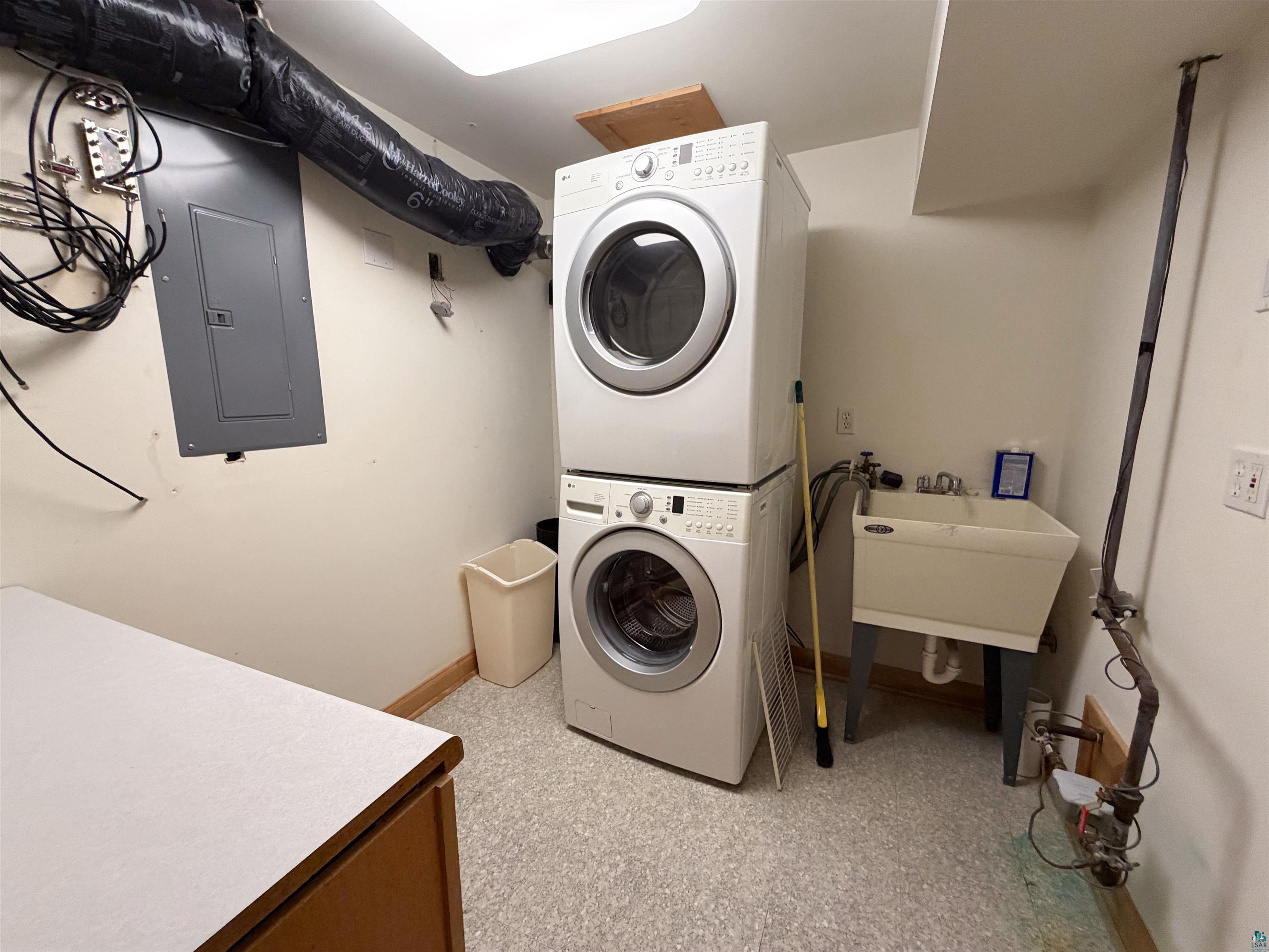 13 West 8th Street Duluth, MN 55806 - Photo 45 of 57 Dedicated laundry area featuring a stacked washer and dryer unit, utility sink, and durable flooring