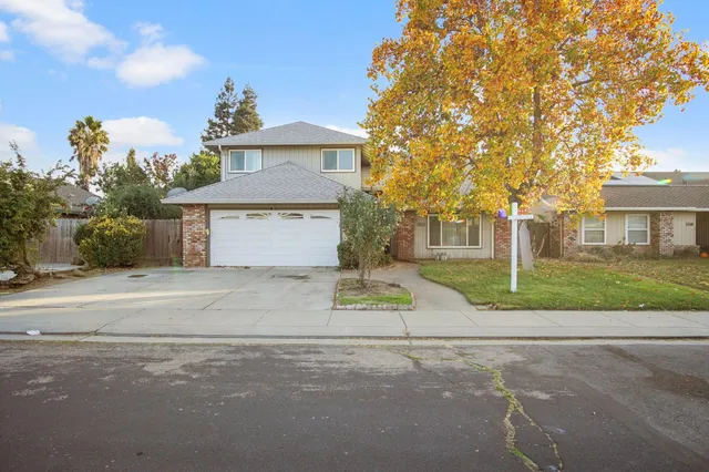 a front view of a house with a yard and a garage
