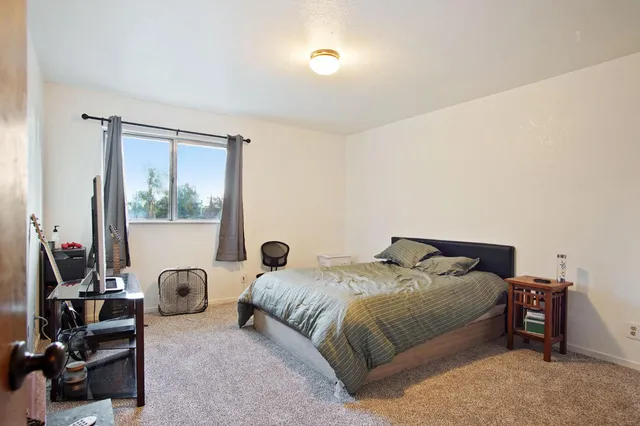 a bedroom with a bed and a large window