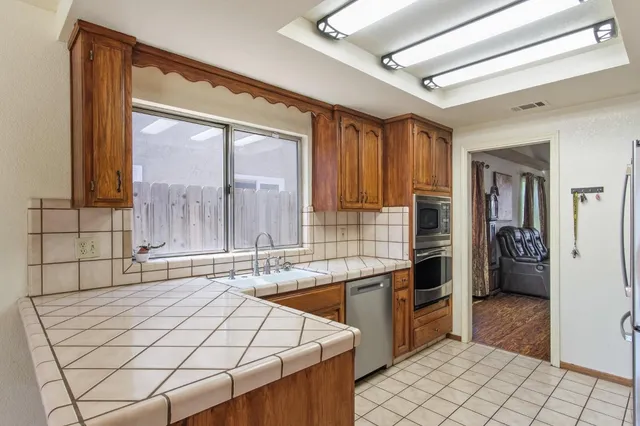 a large kitchen with stainless steel appliances granite countertop a stove and a sink