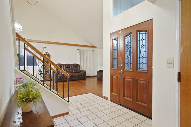 a view of staircase with lots of frames on wall and a potted plant