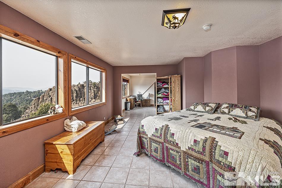 4090 Whiskey Flat Road Reno, NV 89521 - Photo 15 of 29 a bed sitting in a bedroom next to a window