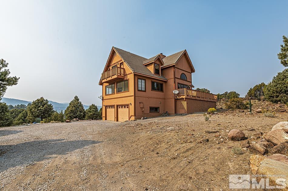 4090 Whiskey Flat Road Reno, NV 89521 - Photo 3 of 29 a front view of a house with a dirt yard and a ocean view