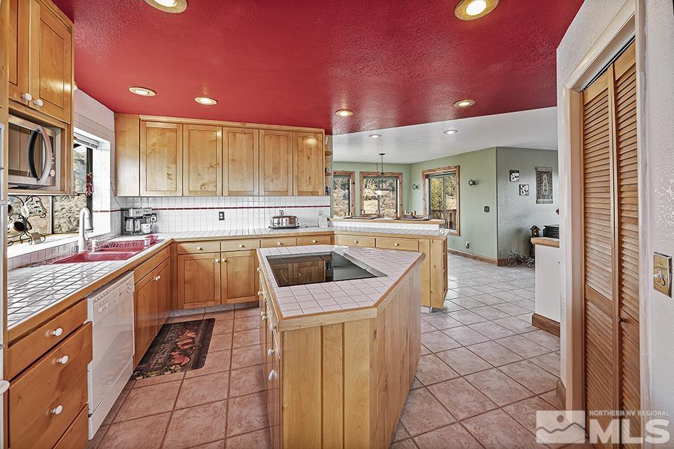 4090 Whiskey Flat Road Reno, NV 89521 - Photo 7 of 29 a kitchen with stainless steel appliances kitchen island granite countertop a sink and cabinets