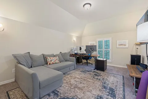 a living room with furniture a window and a flat screen tv