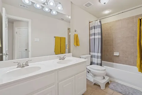 a bathroom with a double vanity sink toilet mirror and shower