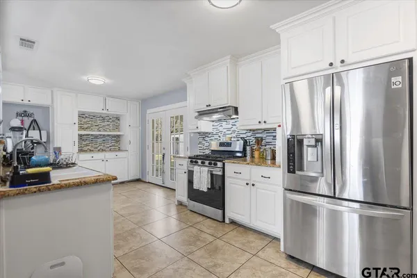 a kitchen with stainless steel appliances a refrigerator sink and stove