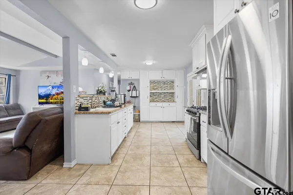a kitchen with stainless steel appliances granite countertop a refrigerator and a sink