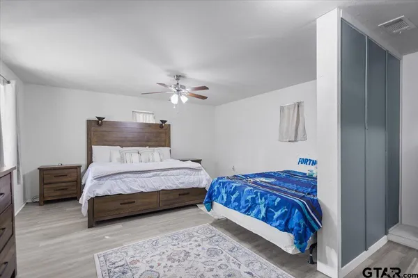 a bedroom with a bed and a lamp on dresser