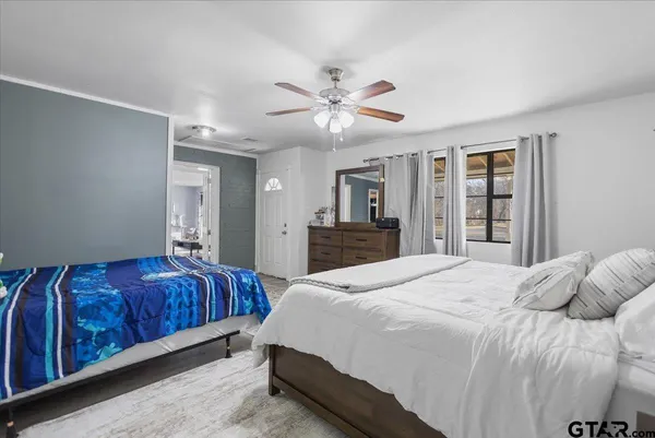 a bedroom with a large bed and ceiling fan