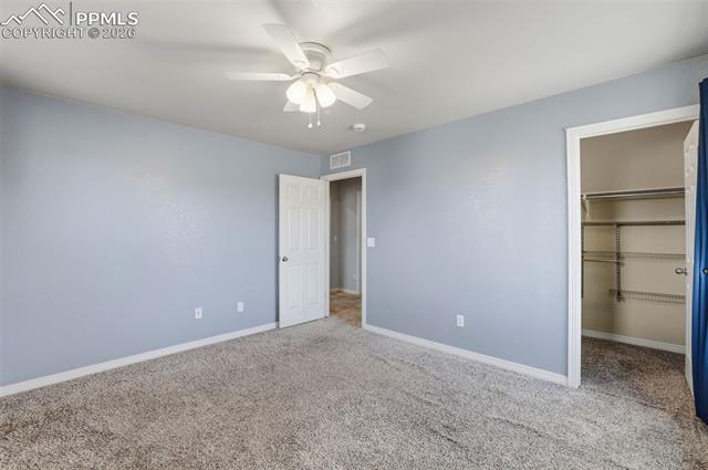 2224 Reed Grass Way Colorado Springs, CO 80915 - Photo 36 of 39 Unfurnished bedroom with a spacious closet, carpet, and ceiling fan
