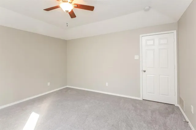 an empty room with a chandelier fan