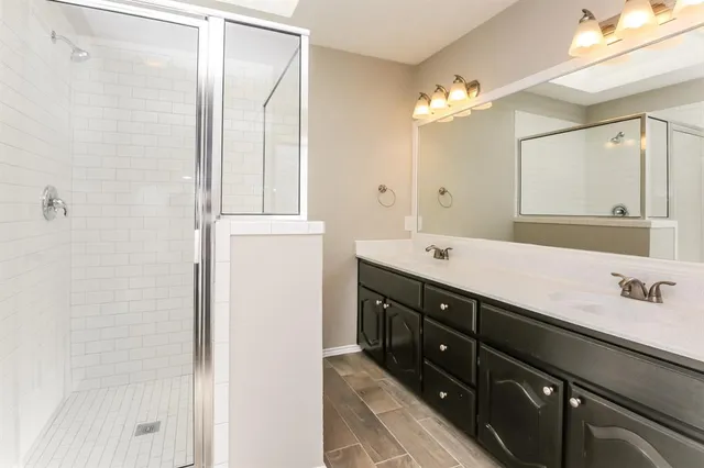 a bathroom with a double vanity sink and a mirror