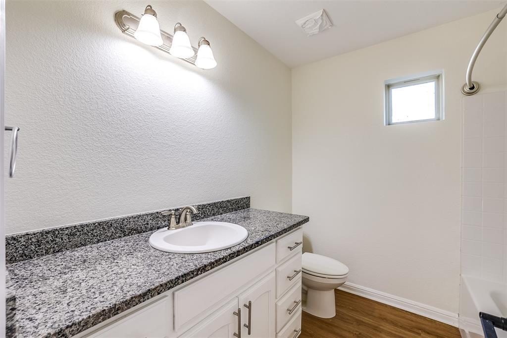 2836 Burchill Road South Fort Worth, TX 76105 - Photo 14 of 18 a bathroom with a granite countertop sink and a mirror