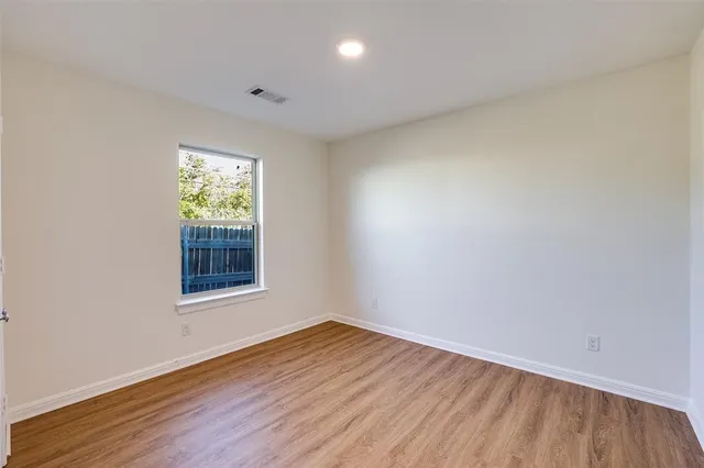 an empty room with wooden floor and a window