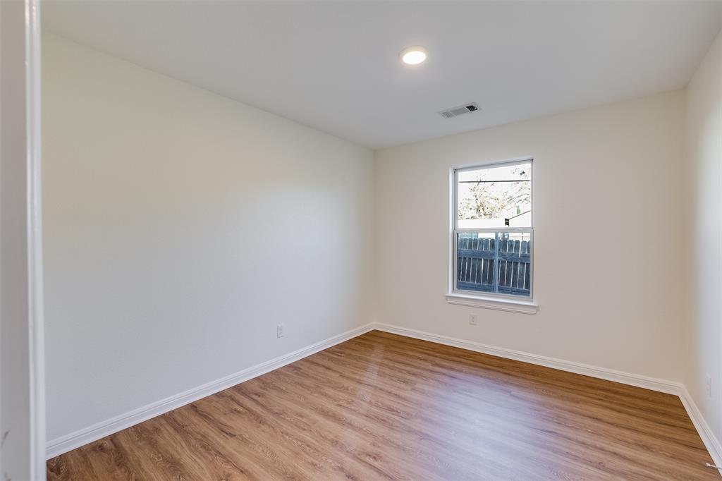 2836 Burchill Road South Fort Worth, TX 76105 - Photo 17 of 18 an empty room with wooden floor and windows
