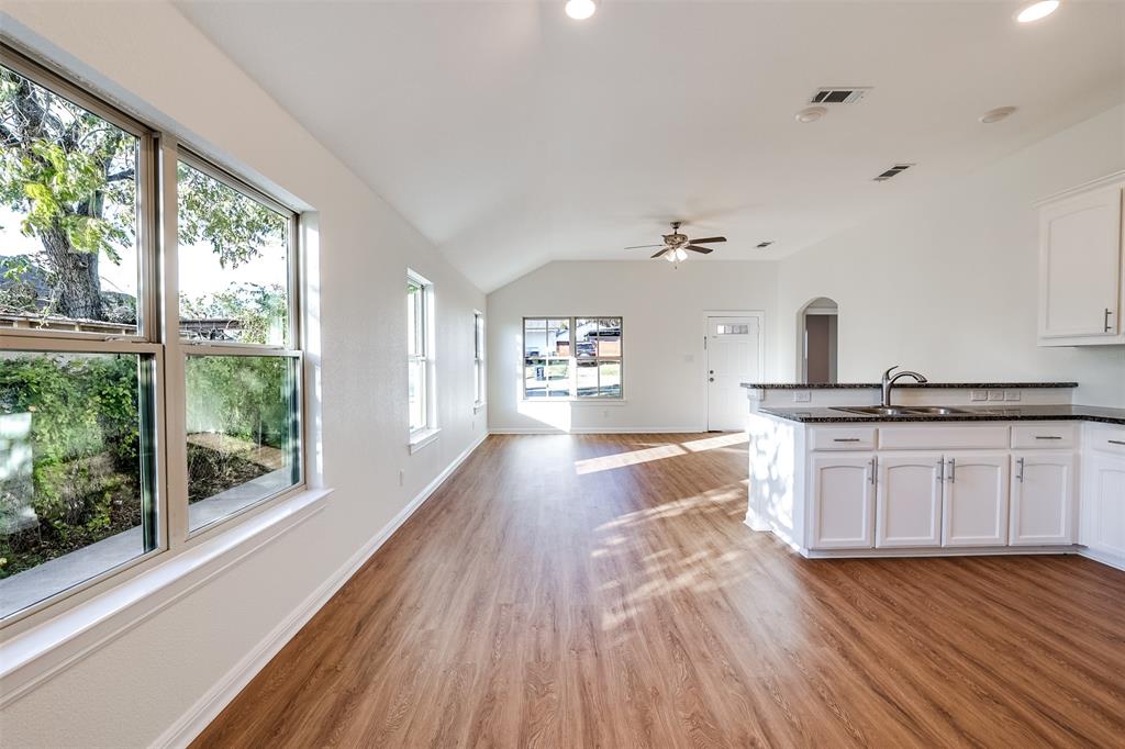 2836 Burchill Road South Fort Worth, TX 76105 - Photo 5 of 18 a kitchen with granite countertop a stove and wooden floor