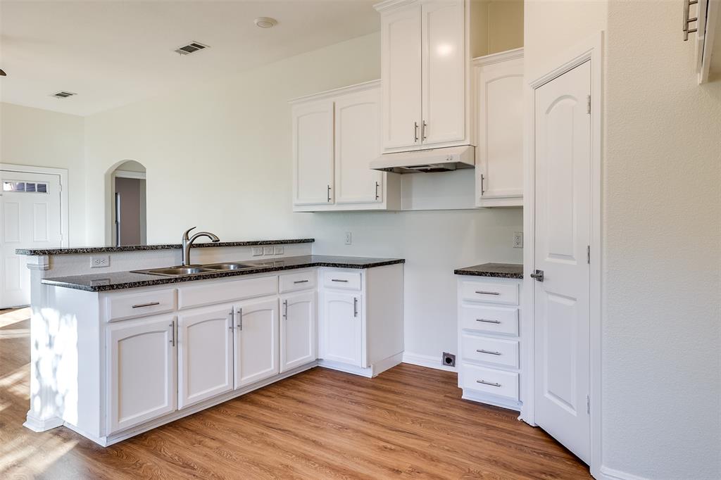 2836 Burchill Road South Fort Worth, TX 76105 - Photo 7 of 18 a kitchen with granite countertop white cabinets and sink