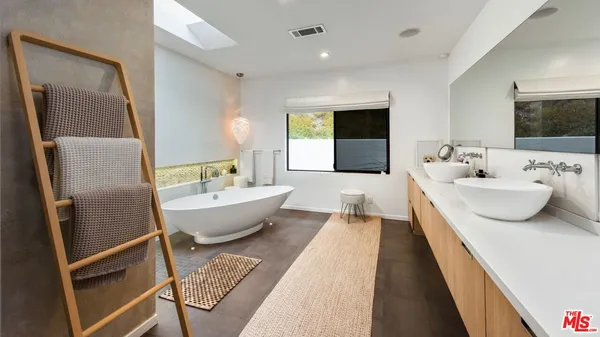 a spacious bathroom with a double vanity sink and a bathtub