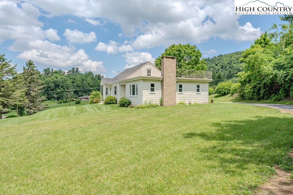 1821 Deerfield Road Boone, NC 28607 - Photo 5 of 33 a front view of a house with a big yard and potted plants