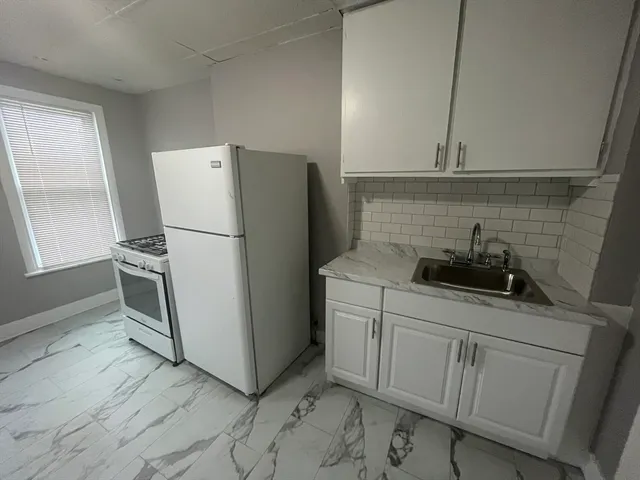 a kitchen with a refrigerator sink and cabinets