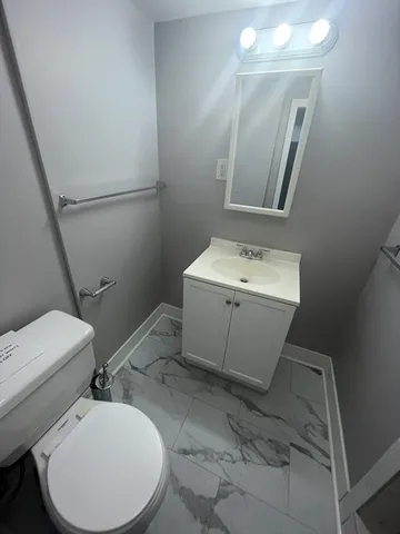 a bathroom with a toilet sink and mirror