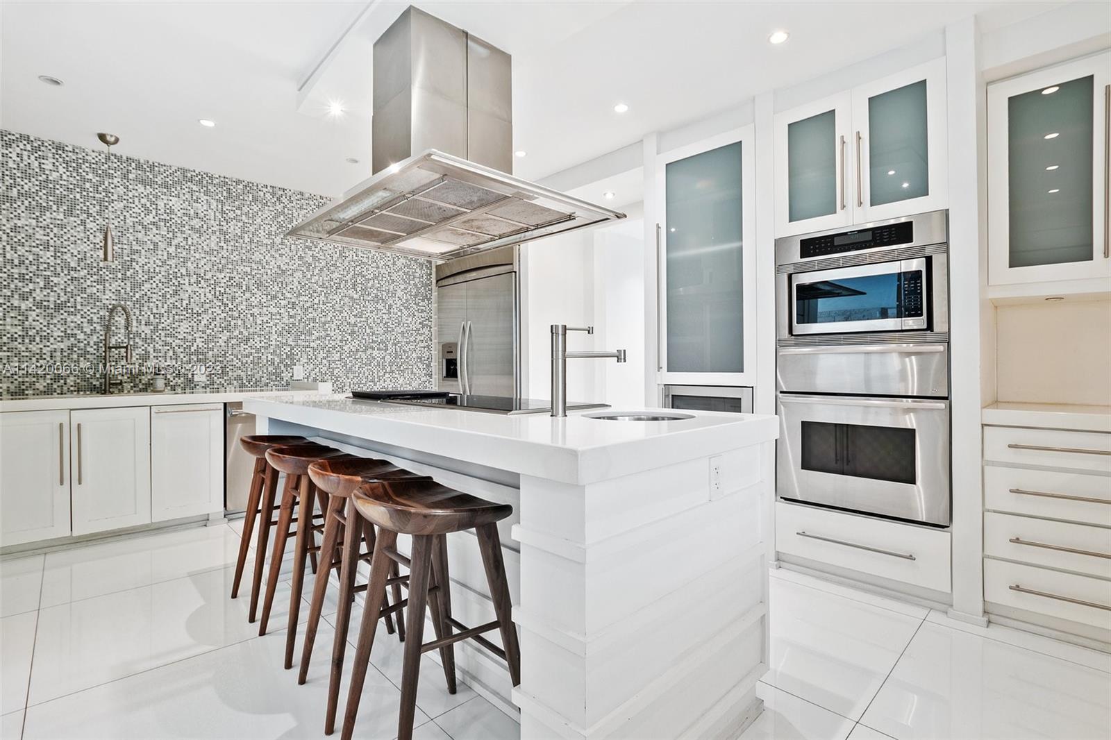 700 Lake Road Miami, FL 33137 - Photo 13 of 59 a kitchen with stainless steel appliances kitchen island a table chairs sink and cabinets