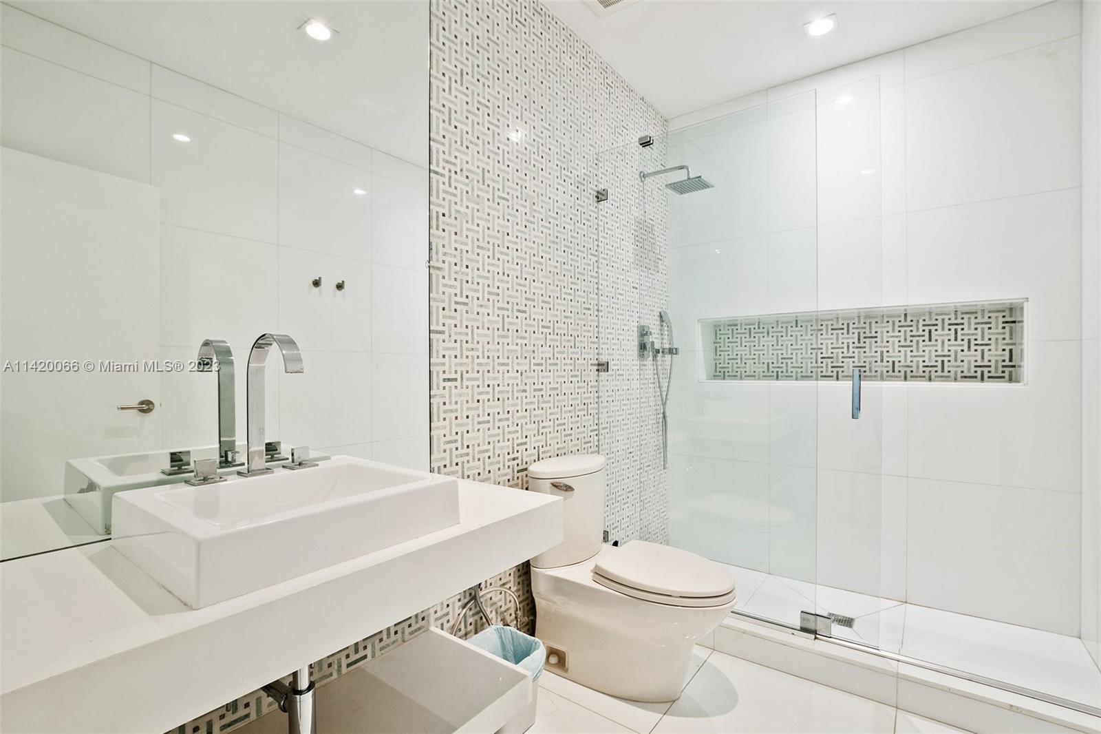 700 Lake Road Miami, FL 33137 - Photo 20 of 59 a bathroom with a sink a toilet a mirror and shower