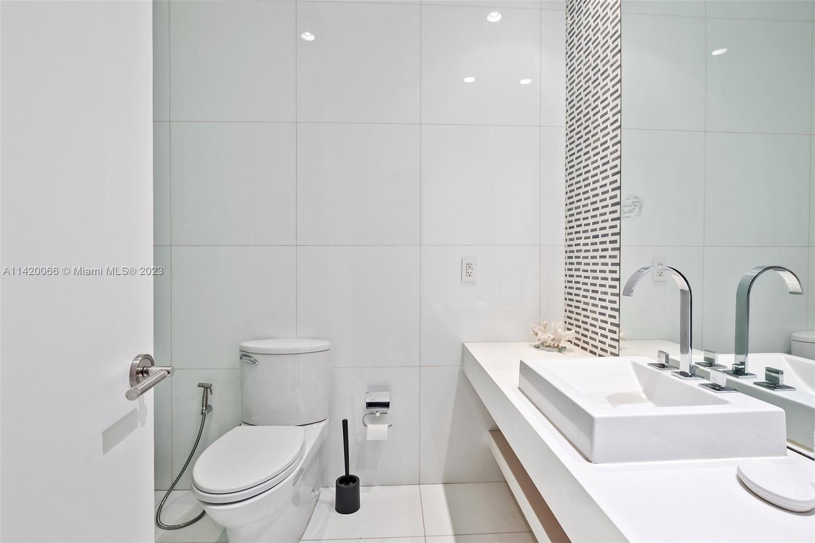700 Lake Road Miami, FL 33137 - Photo 27 of 59 a bathroom with a sink a toilet and a mirror
