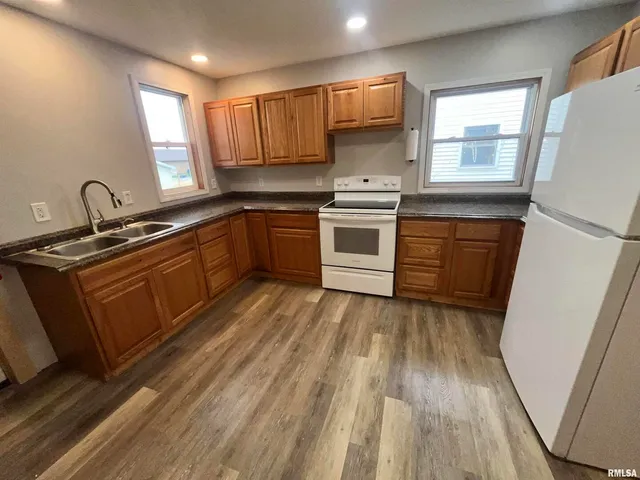 a kitchen with wooden floors and white appliances
