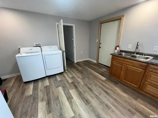 a utility room with wooden floor washer and dryer