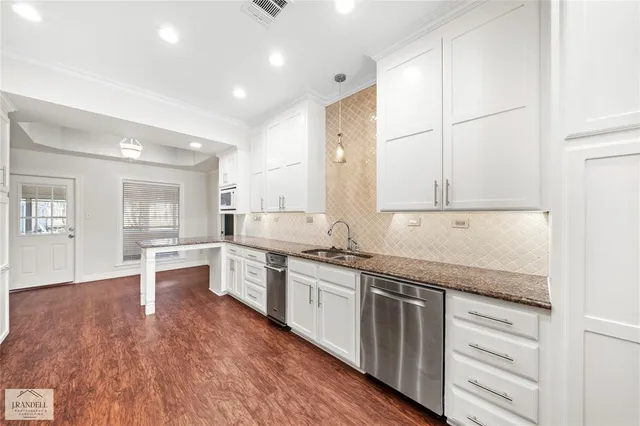 a large kitchen with stainless steel appliances granite countertop a lot of counter space and wooden floors