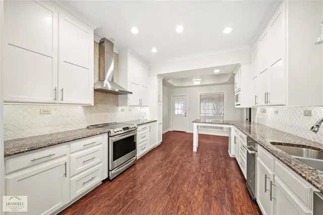 a large kitchen with stainless steel appliances granite countertop a large counter top and a stove top oven