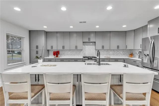 a kitchen with granite countertop white cabinets and stainless steel appliances