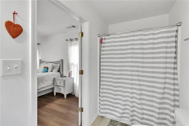 a bedroom with a bed and wooden floor